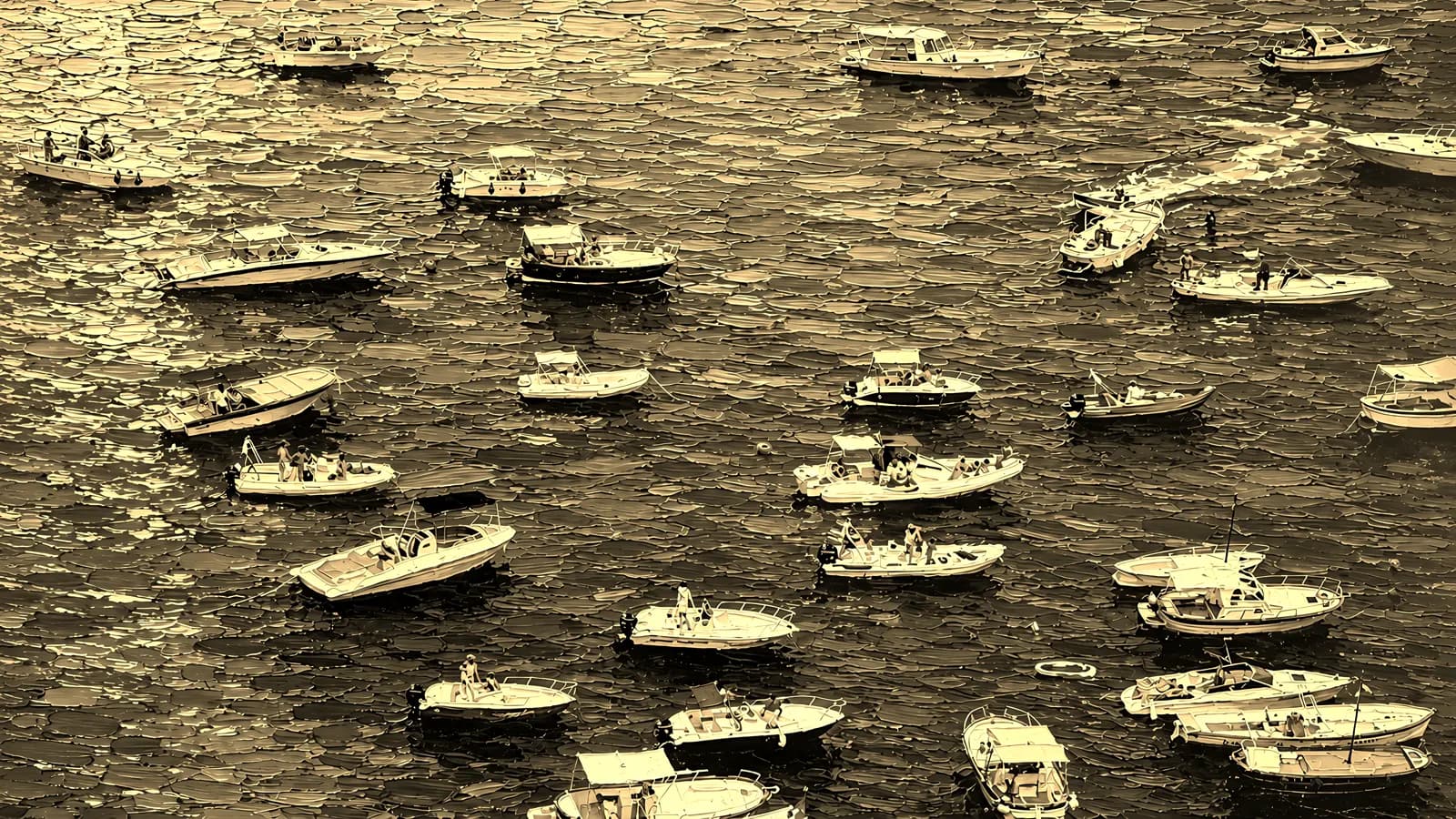 Small boats resting on deep cobalt water, in the Golden Edition